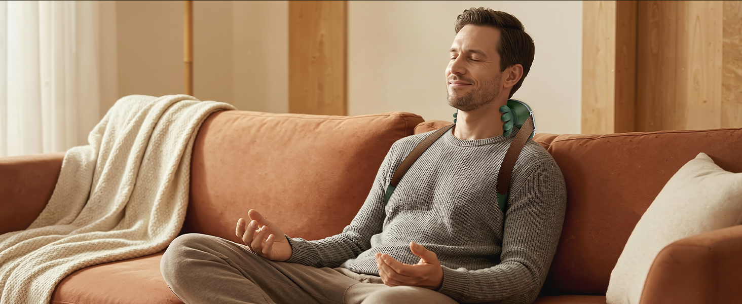 Man relaxing on couch wearing hands-free neck and shoulder massager
