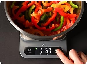 Digital kitchen scale with stainless steel bowl for accurate measurement of fresh chopped peppers