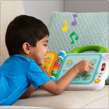 Child smiling and laying with book