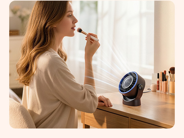 Person applying makeup using a small circular mirror with built-in lighting feature positioned on vanity surface.