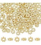 Repeating pattern of small golden or bronze colored decorative elements arranged in rows against a white background.
