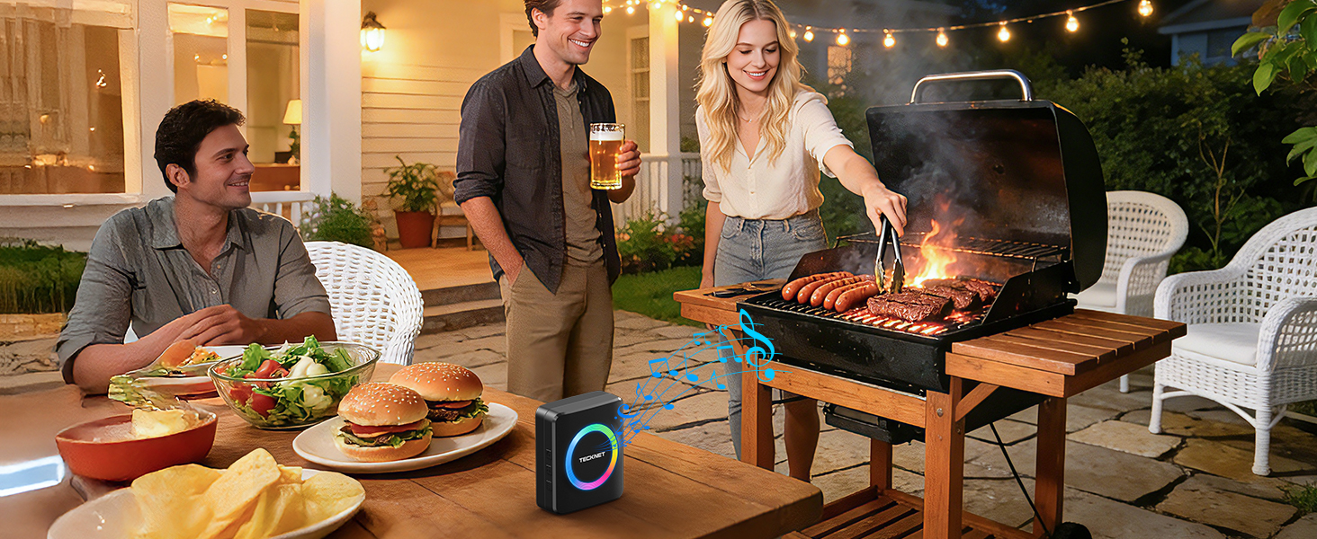 Evening outdoor gathering showing people around patio dining table and grill, with smart speaker device visible in scene.