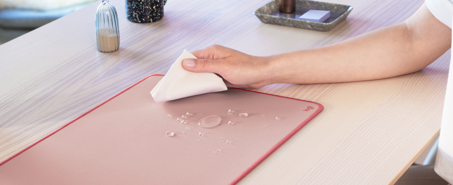 A zoom of a hand cleaning the Desk Mat