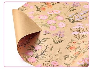 Pink kraft paper roll with floral botanical print featuring pink, orange, and purple flowers with green leaves. Paper shown partially unrolled displaying continuous pattern design on beige kraft paper.