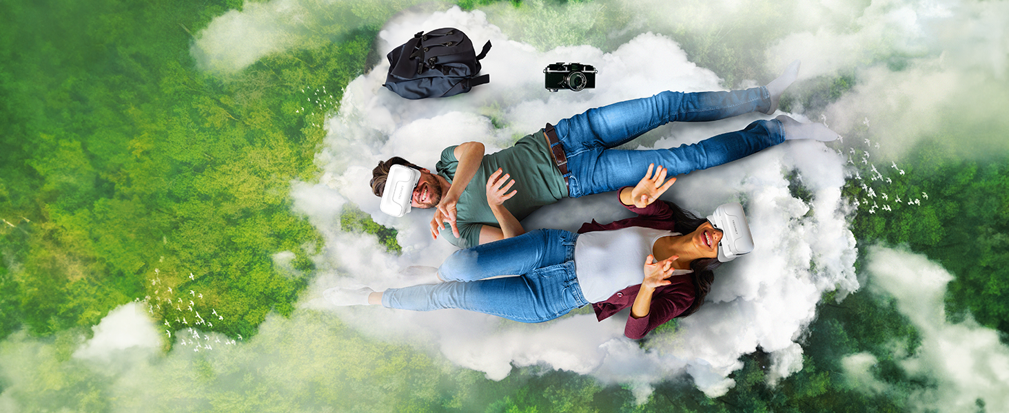 Aerial creative photograph of two people lying on a white cloud formation against a green landscape background.