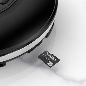 Close-up of a black electronic device with a micro SD card being inserted. The device appears to be a portable music player or recorder.