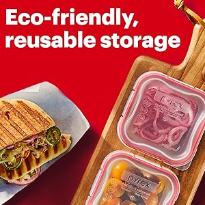 Meal prep containers on a cutting board and a sandwich over red backdrop.