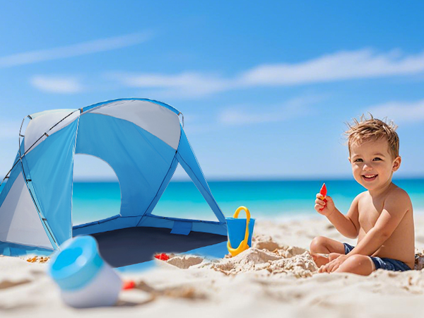 a boy is playing near a beach tent