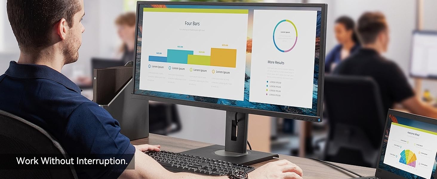 Text reads 'Work Without Interruption'. Office setting showing multiple computer screens displaying data charts and analytics dashboards.