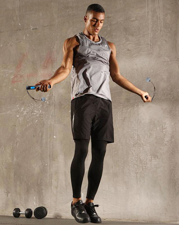 man exercises with cordless jump rope inside room