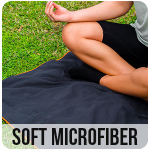 a person sitting on a grass field with their legs crossed.