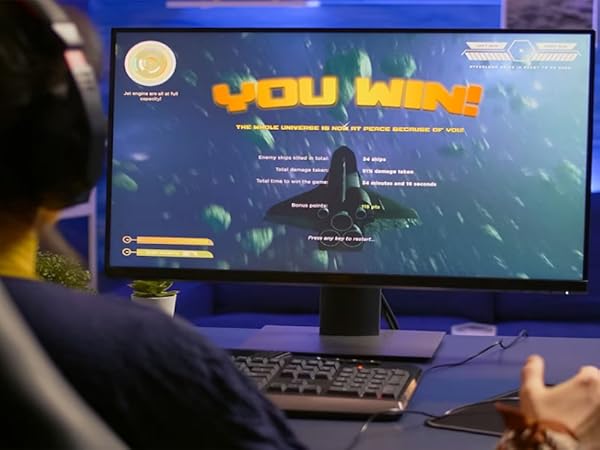 Computer monitor displaying a video game victory screen with 'YOU WIN' in bright text. Underwater scene visible in the background.