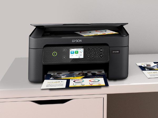 Expression Home XP-4200 printer wirelessly printing from laptop, with document in scanner flatbed.