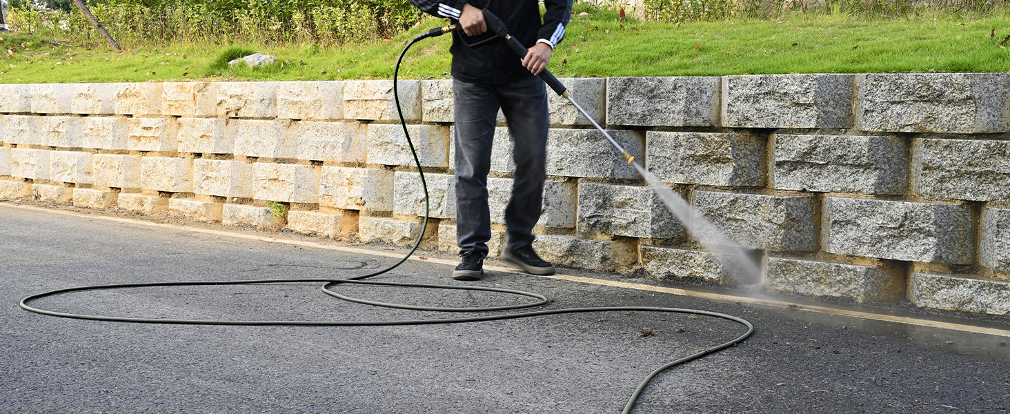 washing the drive way with the pressure washer hose