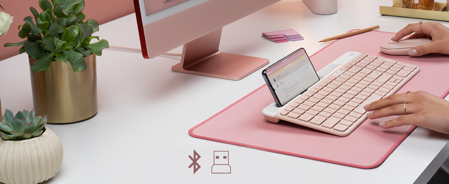 a woman using k585 slim wireless tenkeyless rose keyboard and m350 pebble shaped cordless pink mouse