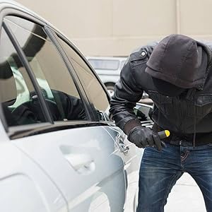 a person with a black hood is breaking into a car.