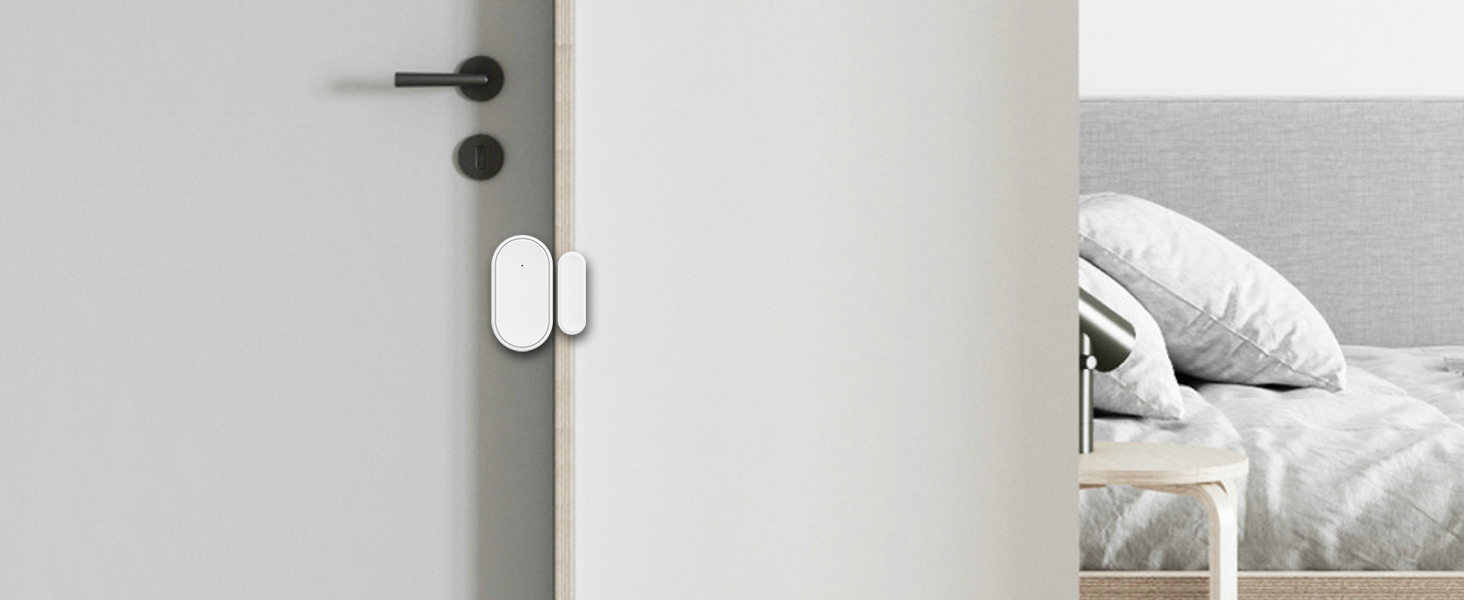 White interior door with silver electronic smart lock installed. Partial view of bedroom with white bedding visible in background.