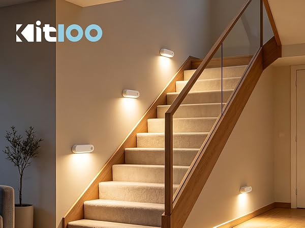 Text reads 'kitioo' branding. Modern staircase with wooden handrail lit by integrated white LED lights along each step, warm ambient lighting in interior space.
