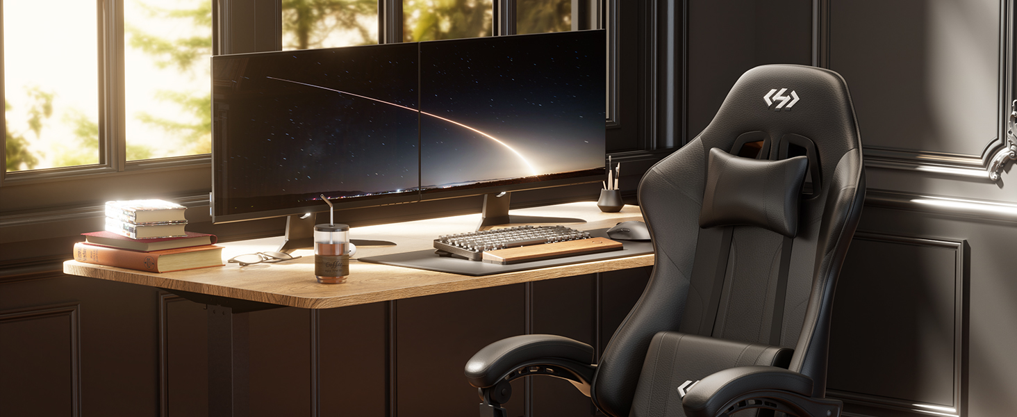 Wooden desk workspace setup in warm lighting with laptop, external monitor, keyboard, and desk accessories arranged neatly.