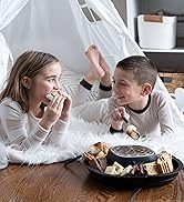 a young girl and boy enjoying Kusini s&amp;amp;#39;mores maker at an indoor tepee sleepover party