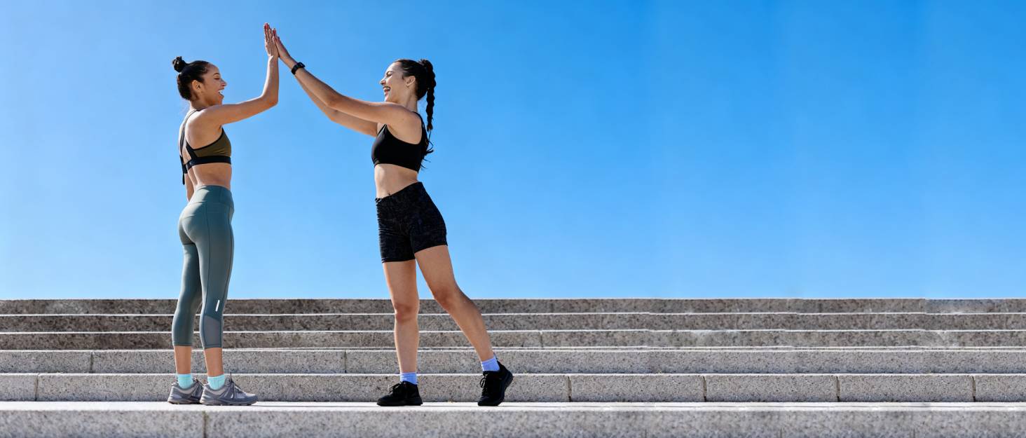 Exercise sequence photos showing two people performing partner stretching exercises outdoors on concrete steps against blue sky background.