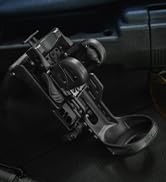 Close-up of a car phone mount attached to an air vent. The mount features an adjustable arm and a grip mechanism for holding a smartphone securely in place.