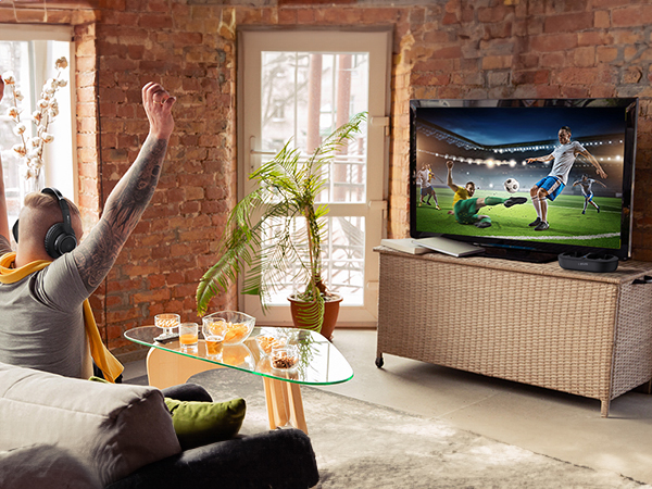 A man watches a wonderful football match with TV headphones