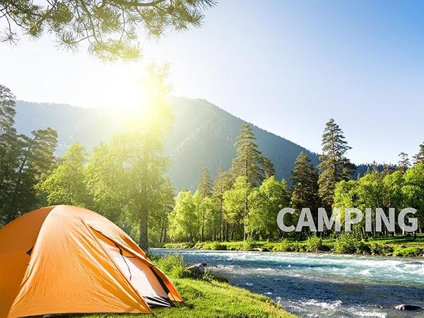 Orange tent pitched by a river in a mountain forest. Sunlight filtering through trees. 'CAMPING' text overlaid on the image.