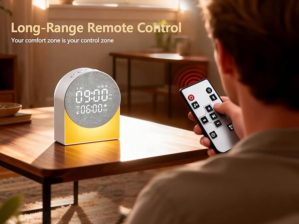 Text reads: 'Long-Range Remote Control' and 'Your comfort zone is your control zone'. Digital clock display device with remote control shown on wooden table in dim lighting.