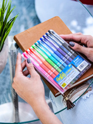 Pilot - A lady holding a pack of pilot pens