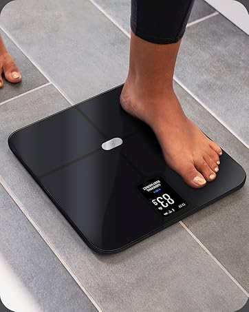 Woman stepping on the Greater Goods Verve AccuCheck Smart Scale in a bathroom