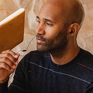 african american man wearing RP-TCM125-K corded glossy black earbuds with white trim and microphone