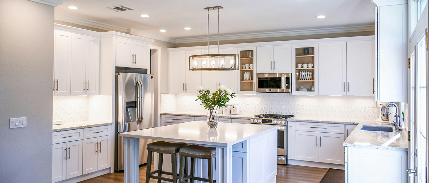 a kitchen with a white island and a white counter.