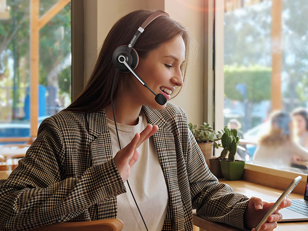 A woman wearing ARA700 wired headset is video-calling a friend.