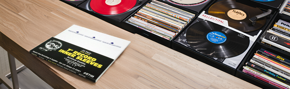 A collection of vintage vinyl records arranged on a wooden surface, surrounded by warm lighting.