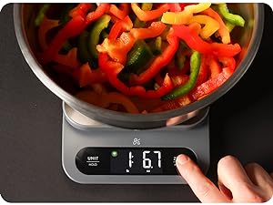 Digital kitchen scale with stainless steel bowl for accurate measurement of fresh chopped peppers