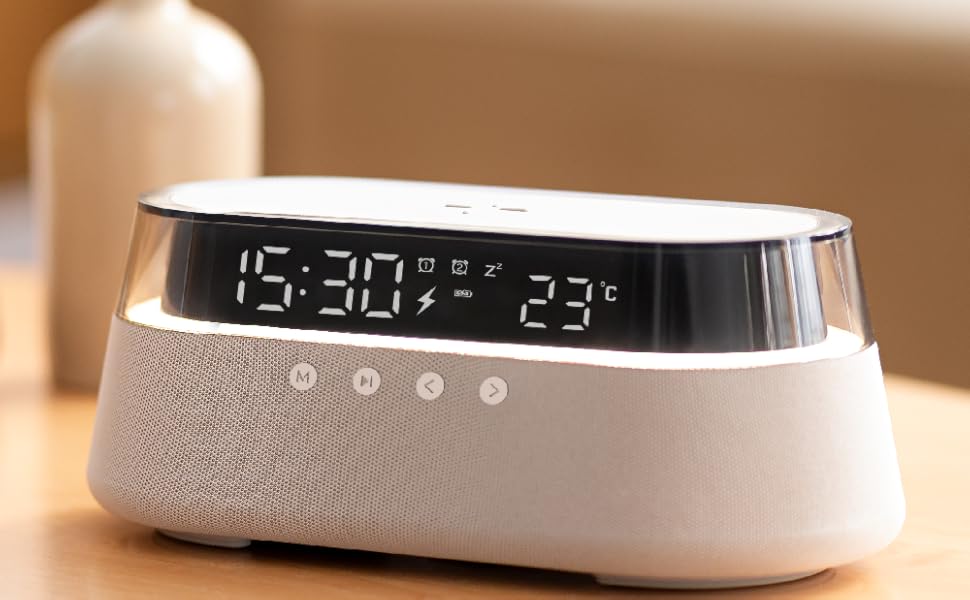 Modern digital alarm clock with LED display showing time and temperature, featuring oval-shaped white housing with fabric texture and touch-sensitive buttons.