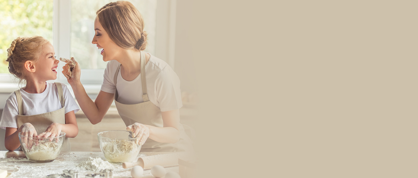 Kitchen scene with baking ingredients and utensils on a countertop, including a mixing bowl and whisk.