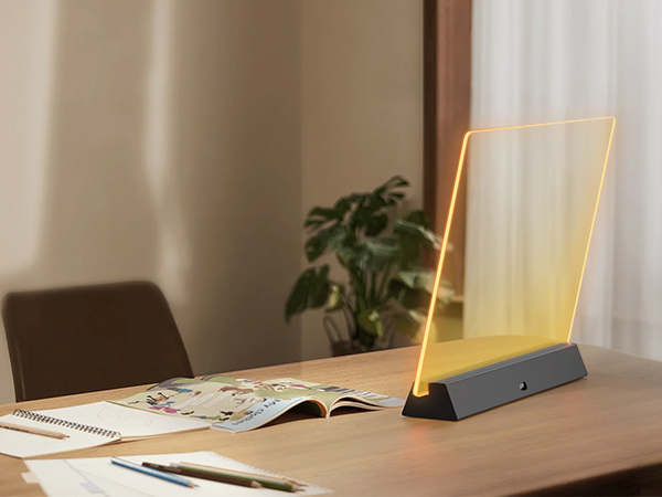 Three slim LED desk lamps with minimalist design featuring vertical light bars mounted on dark bases, arranged on a wooden table with study materials nearby.
