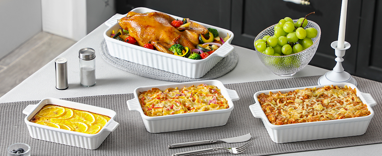 White ceramic bakeware set including rectangular and square dishes. Displayed with roasted chicken, side dishes, and table settings.