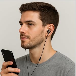 man wearing betron ax5 wired earbuds, holding a mobile phone
