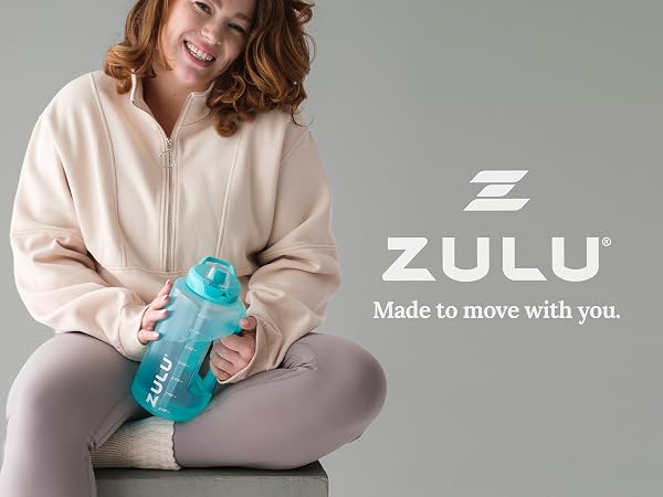 Three women in activewear smile while holding colorful Zulu Goals water bottles.