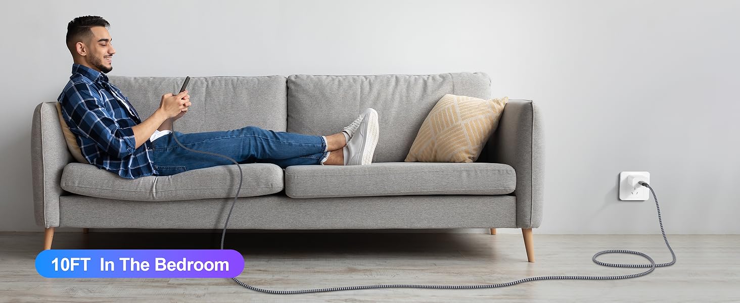 Person relaxing on gray sofa using smartphone. Wall-mounted device visible, labeled 'NET In The Bedroom'.