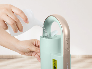 Portable water dispenser with mint green bottle being filled. Features a metallic dispensing mechanism mounted on top.