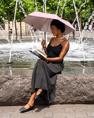 woman reading on sunny day with UPF50 umbrella as shade