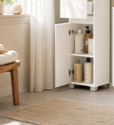 Interior shelving unit with white vertical storage cabinet and wood shelves displaying home organization and storage solutions in bright room.