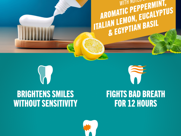 Fluoride toothpaste gel being squeezed onto a toothbrush with lemon and basil denoting freshness