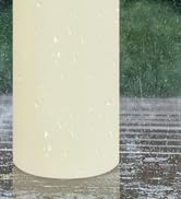 Partially visible cylindrical clear glass container or vessel against a green background.