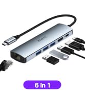 6-in-1 USB hub or docking station. Silver device with multiple ports and attached cable. Various connectors or adapters visible.