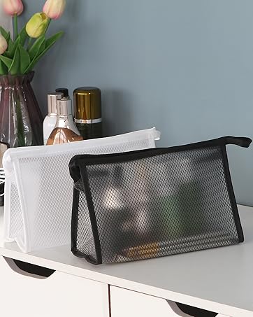 2 black and white cosmetic bags on a white desk